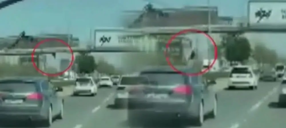 AFİŞ ASARKEN ÜST GEÇİTTEN DÜŞÜP ARABALARIN ALTINDA KALDI!